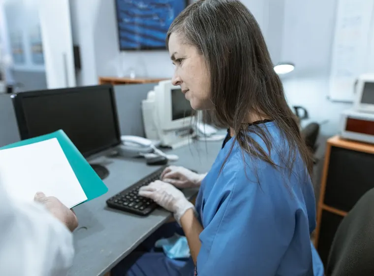A clinician working at a computer workstation