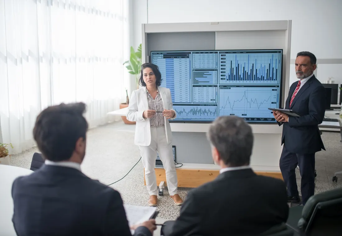 Colleagues reviewing dashboards on screen in a meeting room
