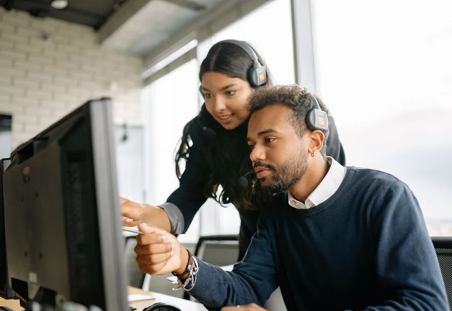 Two engineers working through an issue at a monitor