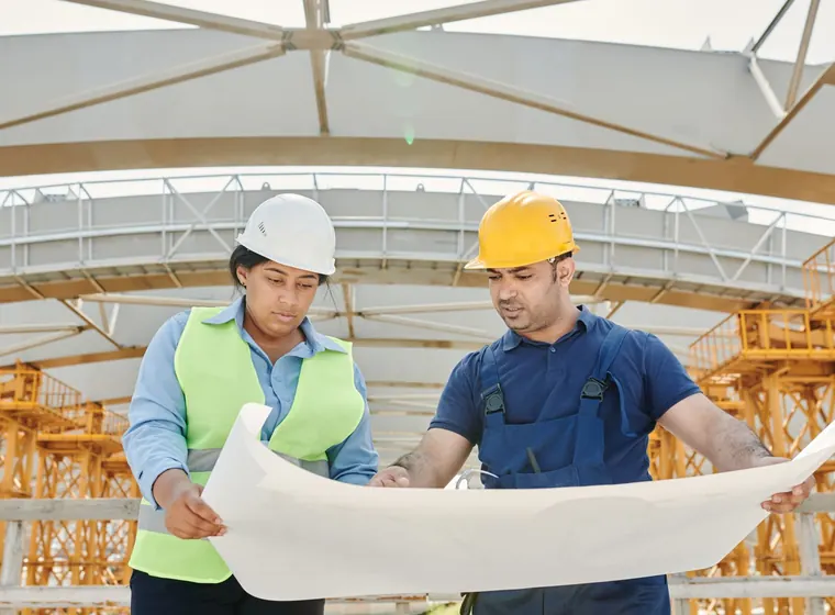 Engineers reviewing plans on an infrastructure site